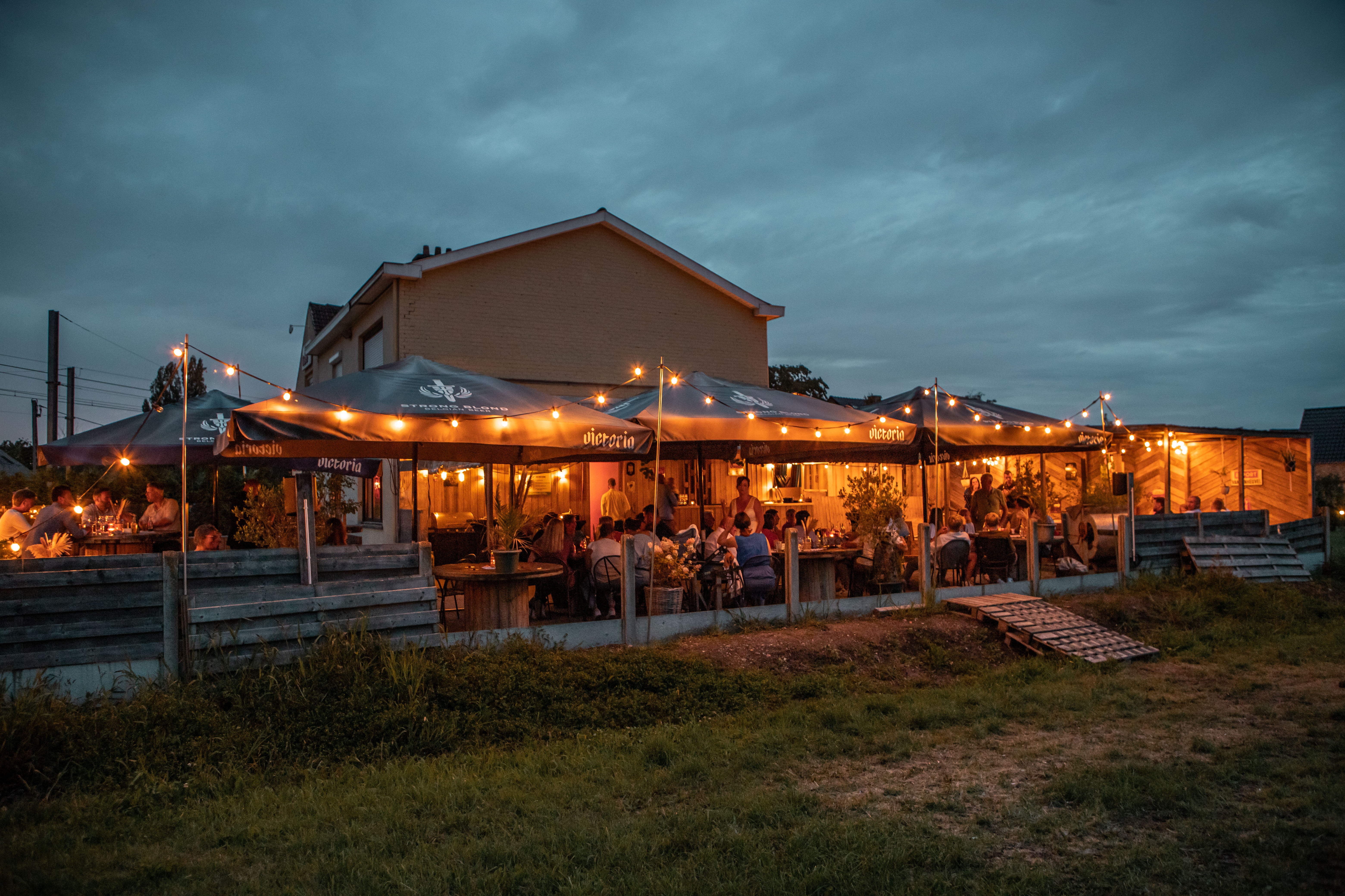 Privé-event met verlichte tenten en gasten op het terras van Den Bled in Heffen